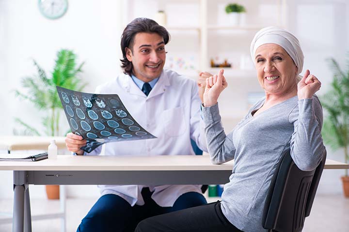 Cancer patient celebrating good news while doctor reviews her scans