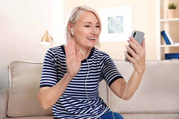 Grandmother using her cell phone to video chat with family
