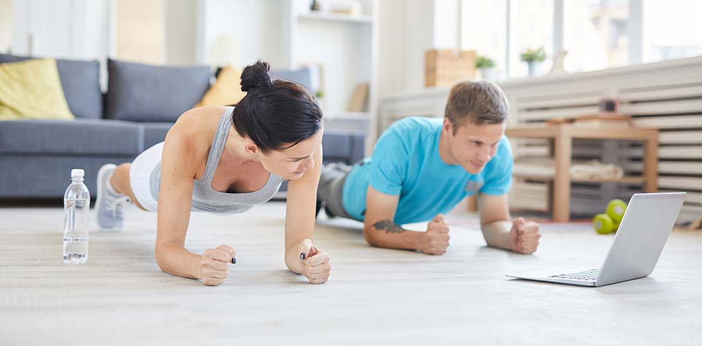 A couple working out at home in a plank position