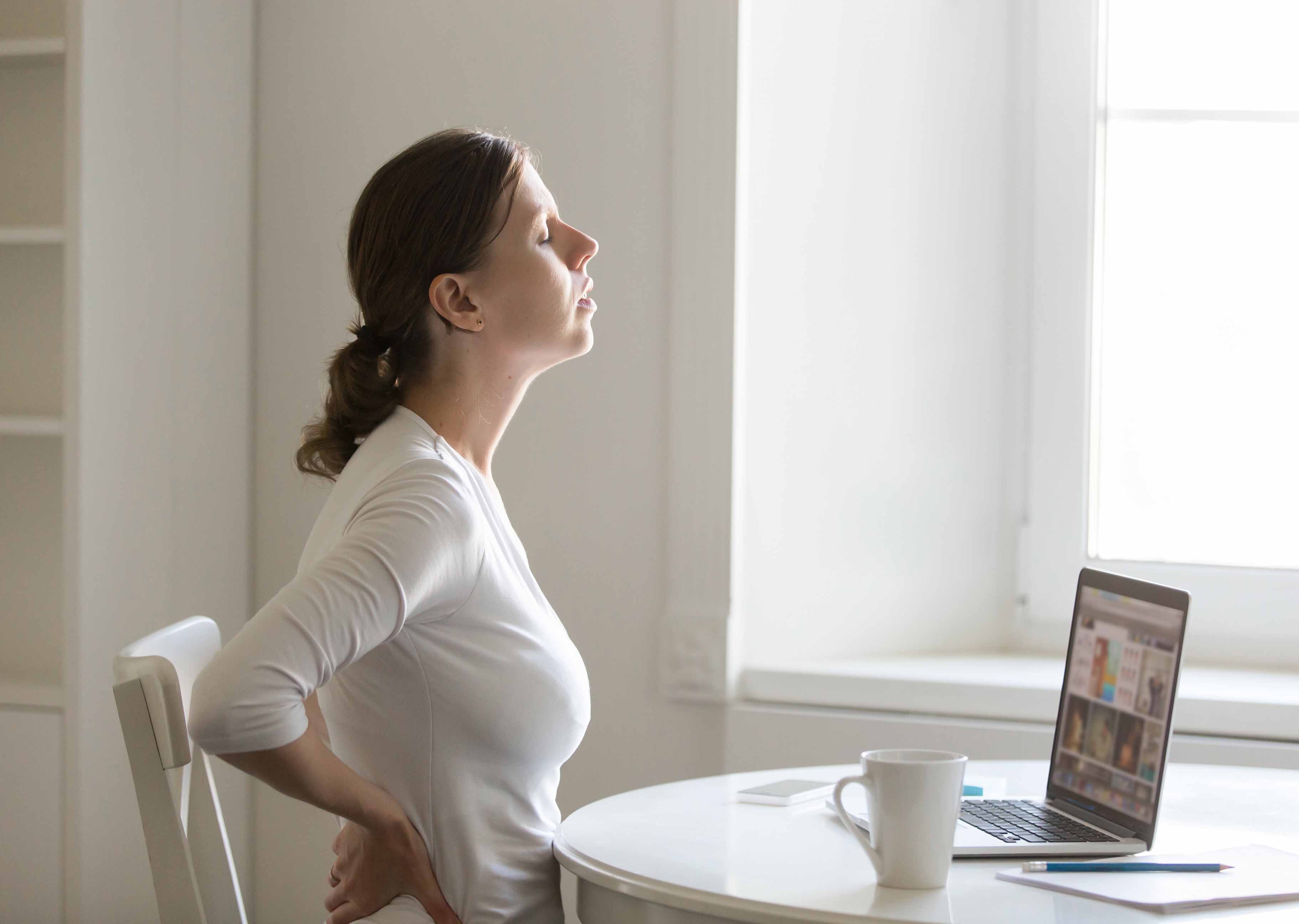 A woman with spinal pain due to posture at work.