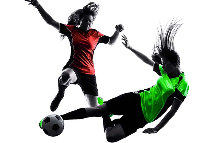 Soccer players, one in a red shirt carries the ball and another in a green shirt tries to take it off