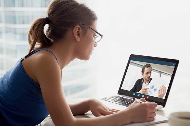 Woman with glasses on a virtual training session with a male coworker