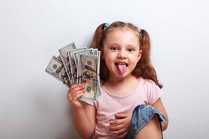 A young girl with a stack of money in one hand and sticking out her tongue